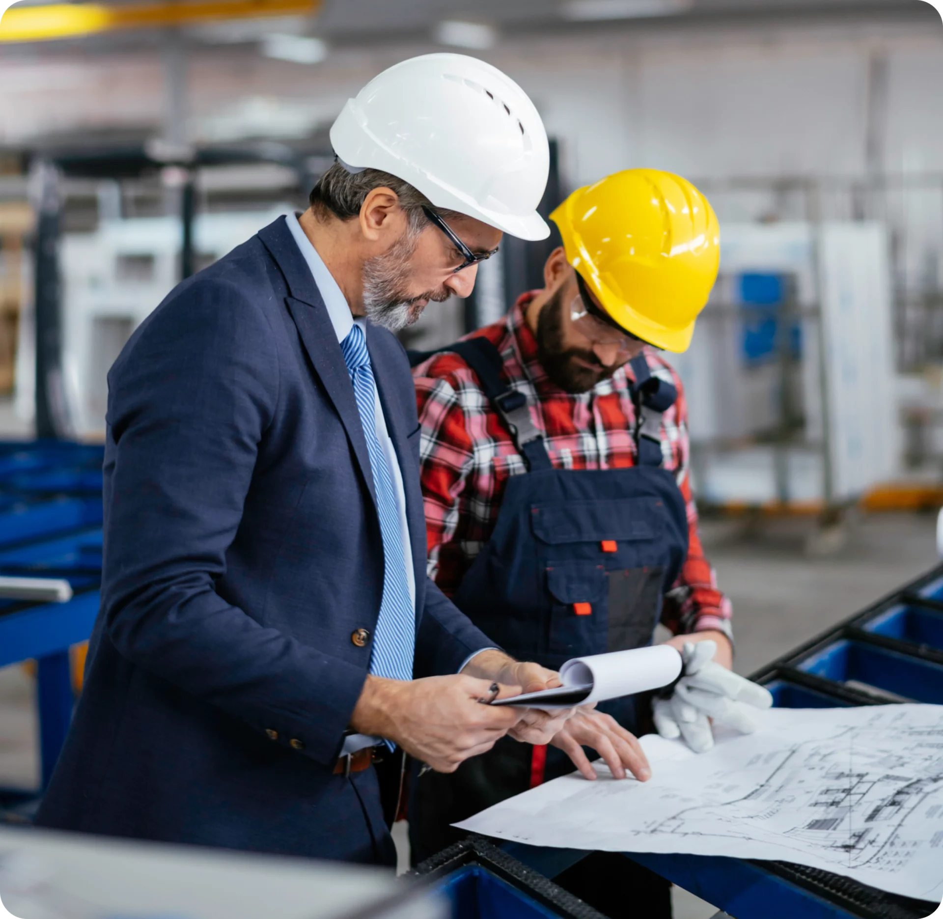 Engineers reviewing blueprints at construction site.